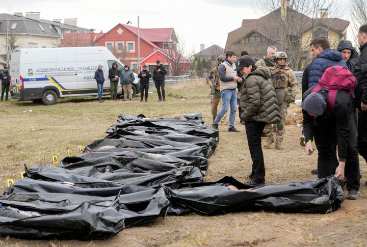 Ukrainian Prosecutor General Iryna Venediktova, center, looks at the exhumed bodies of civilians killed during the Russian occupation in Bucha, on the outskirts of Kyiv, Ukraine.