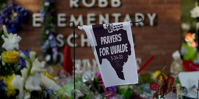 A banner hangs at a memorial outside Robb Elementary School on Friday, June 3.