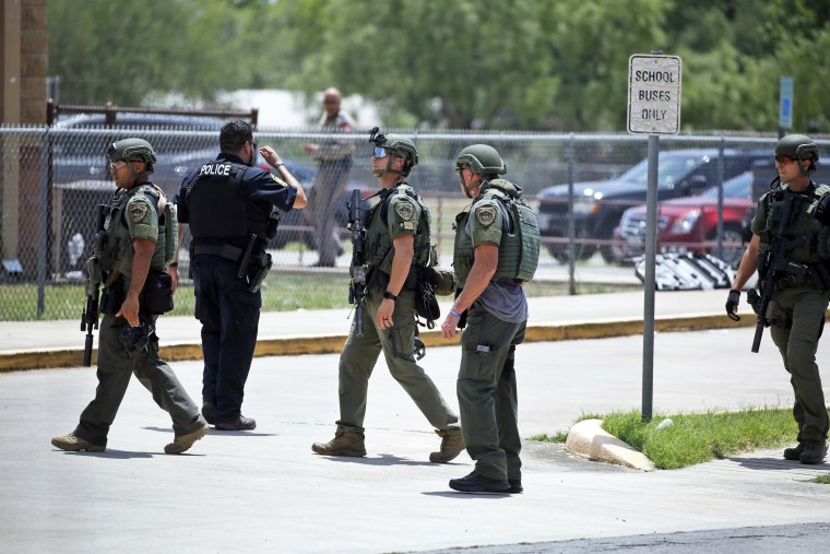 Law enforcement personnel stand outside Robb Elementary School