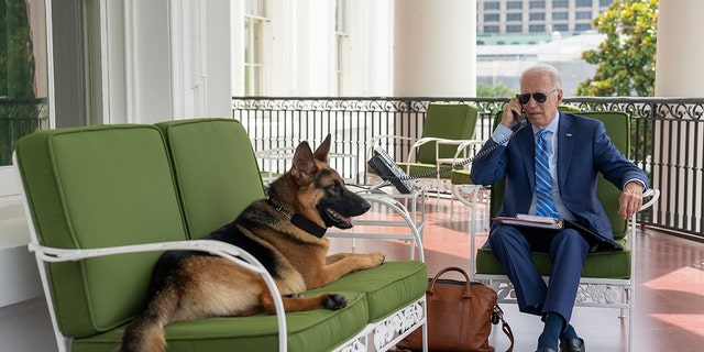 In this image provided by the White House, President Joe Biden speaks on the phone with White House chief of staff Ron Klain from the Truman Balcony, Monday, July 25, 2022, at the White House in Washington.