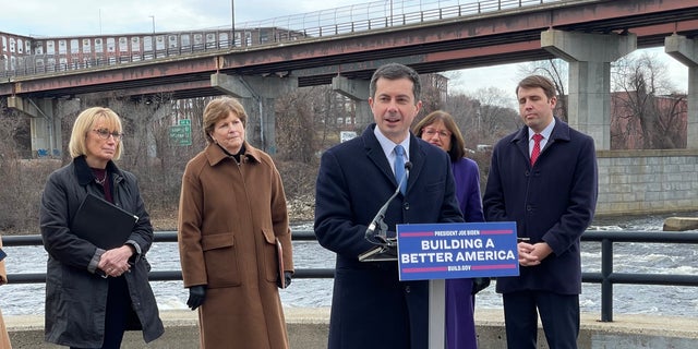 Transportation Secretary Pete Buttigieg, joined by New Hampshire's all Democratic congressional delegation (L to R: Sens. Maggie Hassan and Jeanne Shaheen, and Reps. Annie Kuster and Chris Pappas), speaks at a news conference in Manchester, N.H. on Dec. 13, 2021
